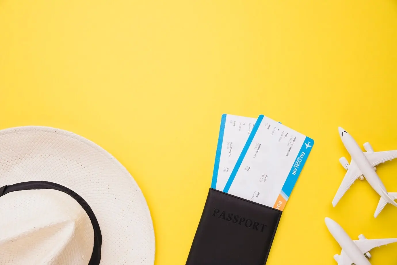 Anordnung von Spielzeugflugzeugen, Reisepass, Tickets und Hut